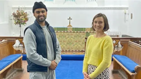 PA Media Sabah Ahmedi, 28, (left) who is one of Britain's youngest Imams, with Charlotte Mathias, treasurer at All Saints Church in Tilford, Surrey