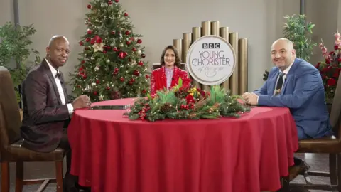 Tricia Yourkevich BBC Young Chorister of the Year judges sitting around a table with a Christmas tree behind them