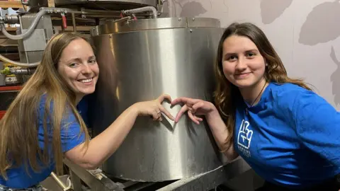 Swindon Welcomes Ukraine Two woman in front of a beer vat