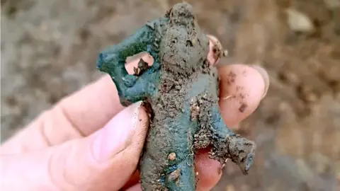 Oxford Cotswold Archaeology Someone holding a cupid figurine