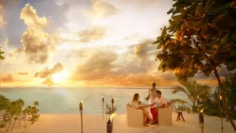 The Brando Couple having dinner on sandy beach at sunset