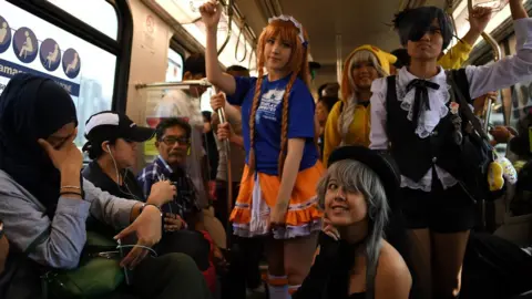 AFP Malaysian cosplayers dressed in costumes pose amidst passengers onboard a Light Rapid Transit (LRT) train during a 'Commuter Cosplay' event in Kuala Lumpur on July 8, 2017.