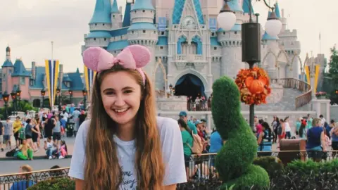 Emily Talbut Emily at Disneyland in front af a castle