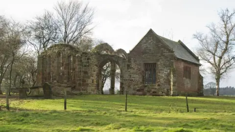 Historic England An old church next to a ruined wall