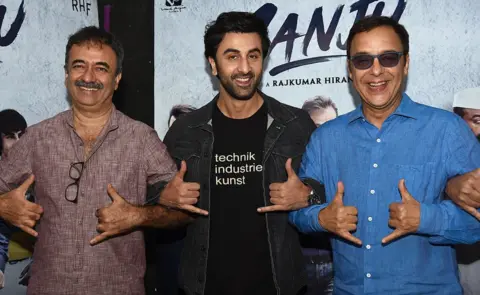 Getty Images Actor Ranbir Kapoor (C) with director Rajkumar Hirani (L) producer Vidhu Vinod Chopra (R) in Mumbai for the film's promotion.