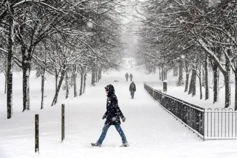 AFP People walk through the snow in Victoria Park in Glasgow on 9 February 2021