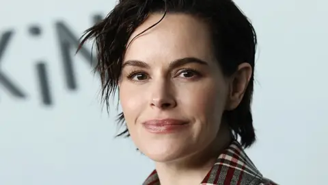 Emily Hampshire close up portrait, with short brown hair