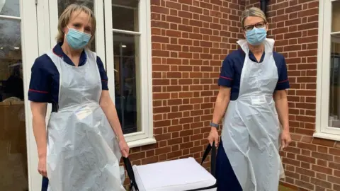 Lead nurse Nicole Spriggs (left) and general practice nurse Anne Ison (right) arriving with vaccine.