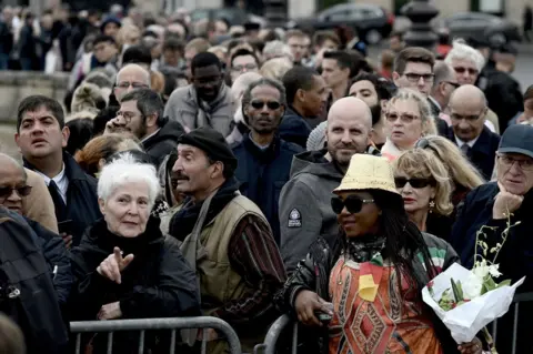 AFP People wait to attend a public ceremony in homage to former French President Jacques Chirac on 29 September 2019.