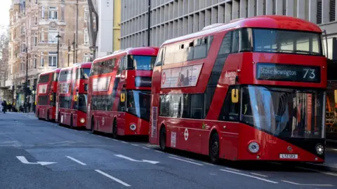 Red London New Routemaster buses parked in-line just off Oxford Street on 6th February 2023