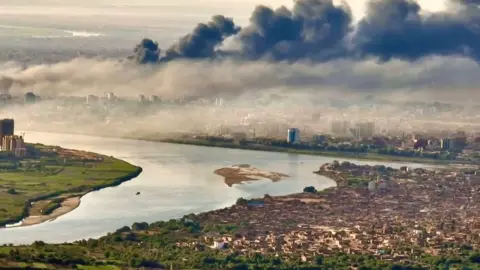 Getty Images An aerial view of black smoke covering the sky above the Sudanese capital Khartoum