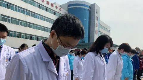 Getty Images Medics in Wuhan mourn those who have died from coronavirus in China