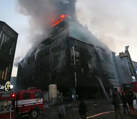 Getty Images Flames and smoke billow from an eight-storey building after a fire broke out in Jecheon, 120km southeast of Seoul, 21 December 2017
