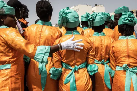 John Wessels / AFP Schoolgirls get ready to take part in celebrations for Senegal's 63rd Independence Day in Dakar on 4 April 2023