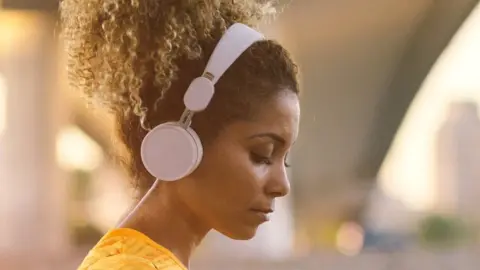 Getty Images Woman listening to music