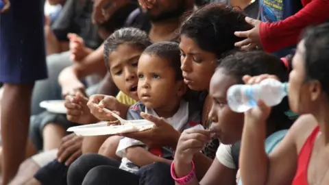 Reuters Venezuelan migrants eat after arriving on Los Iros Beach after their return to the island, in Erin, Trinidad and Tobago, November 24, 2020.