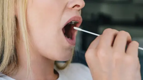 Getty Images Woman using a Covid-19 swab.