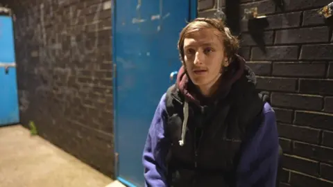 BBC Samuel Atkinson sitting outside a homeless shelter