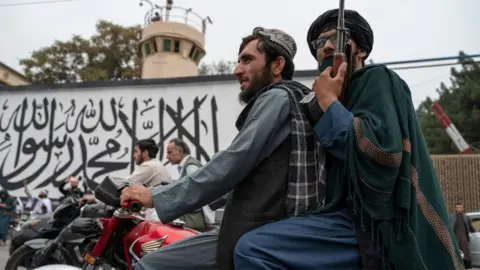 Getty Images Taliban fighters patrol the streets in Kabul on the anniversary of the fall of Afghanistan to the Taliban