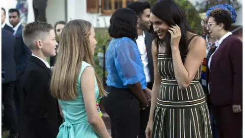 EPA Megahn speaks to Jade Bothma, centre, and Hunter Mitchell before handing them the Commonwealth Point of Light award during a reception for young people