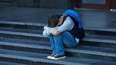 Getty Images Child cries on steps