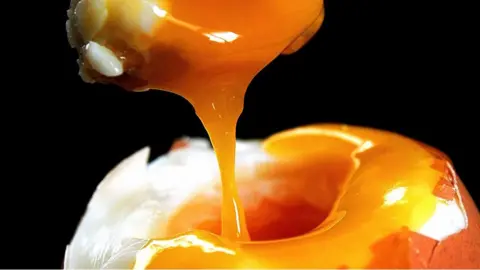 Toast being dipped in runny egg