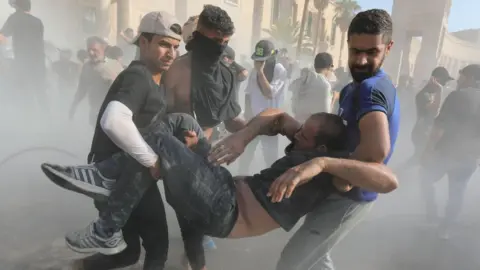 EPA Iraqi men carry a casualty (30/08/22)