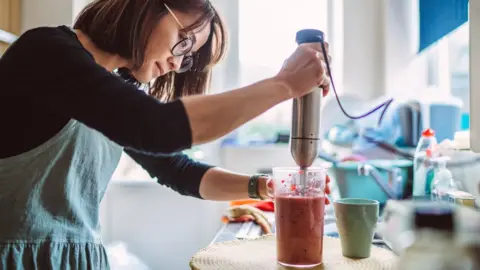 Getty Images Woman making a smoothie