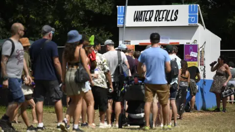 Getty Images Festival-goers queue at a water refill point during day two of Glastonbury Festival