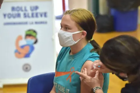 Getty Images Molly Day gets her first Pfizer Biontech COVID vaccine at Ridley High School Monday afternoon May, 3, 2021 as part of a clinic for students age 16-18.