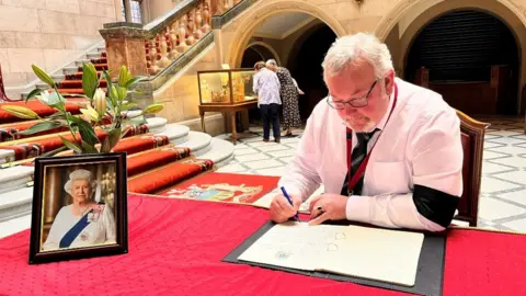 Sheffield City Council Sheffield council leader councillor Terry Fox signs the book of condolence at the Town Hall