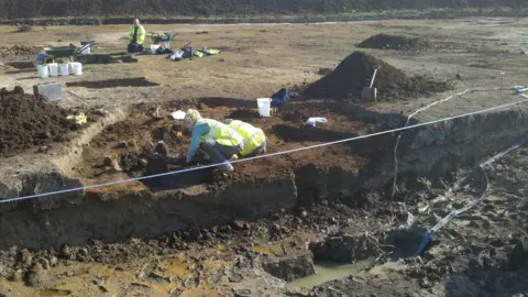 Oxford Archaeology Archaeologists working in the waterlogged pit