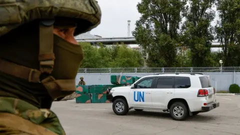 Reuters A car transporting members of the International Atomic Energy Agency (IAEA) expert mission drives past a checkpoint