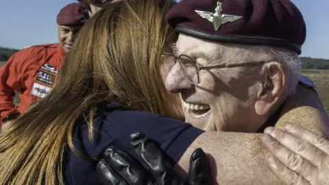 Cpl Robert Weideman/MOD Veteran Sandy Cortmann, 97, getting a hug from his carer, Arlene Campbell just after his tandem jump.