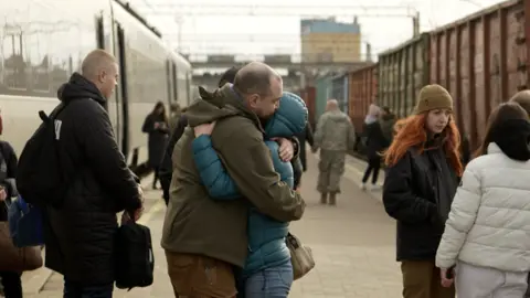 BBC/XAVIER VANPEVENAEGE Two people hug at Kramatorsk train station