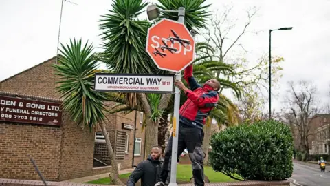 Men remove Banksy artwork