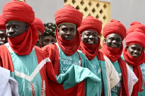 AFP Palace guards dressed in red and green, including large red turbans, stand as candidate of the ruling All Progressives Congress (APC) arrives to pray at Central Mosque, in his native town of Daura in Katsina State, Nigeria - Friday 15 February 2019