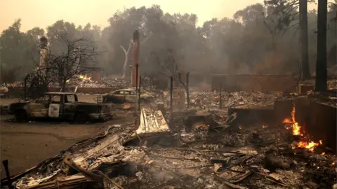 Getty Images Burned out wreckages of houses and cars are pictured