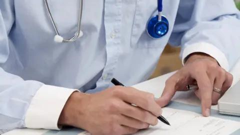 Science Photo Library Doctor writing medical notes