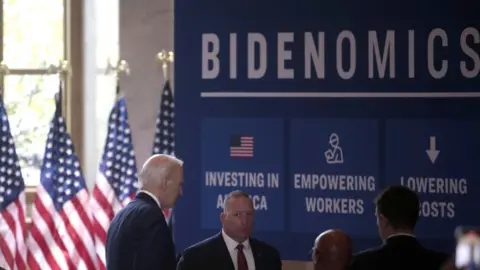 EPA Biden in front of sign that reads: Bidenomics