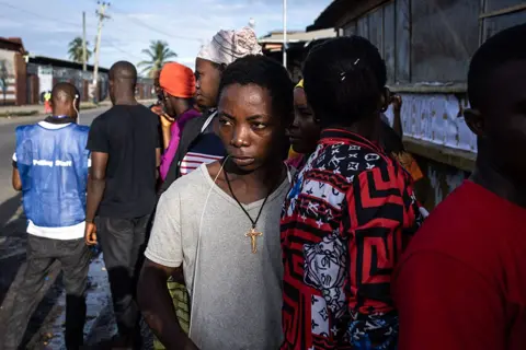 John Wessels / AFP A voter waits in line at a voting station for the polls to open in Monrovia