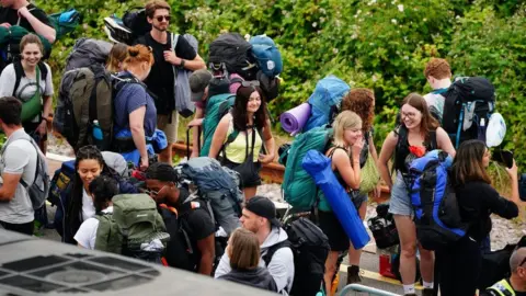 Ben Birchall/PA Wire Festivalgoers at Castle Cary train station