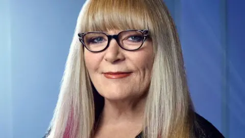 Ve Neill Woman with long blonde hair and glasses