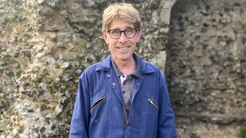 Sue Warren Stonemason Jonathan Presley within the abbey gardens