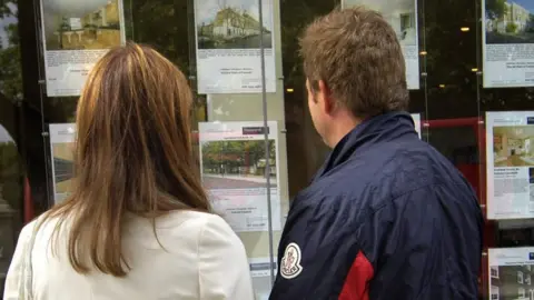 People looking in estate agent's window