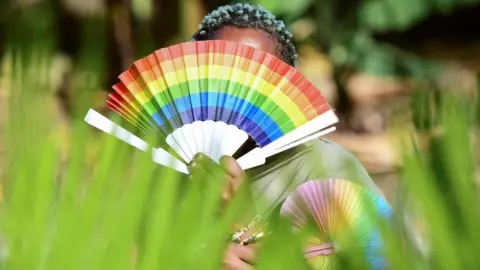 Reuters Woman has a rainbow fan in Uganda