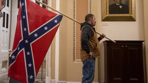 EPA A protester carries the Confederate flag into the US Capitol building