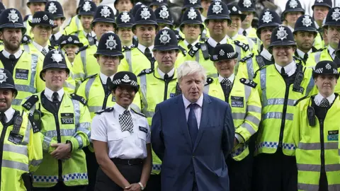 Getty Images Boris Johnson standing with dozens of police officers