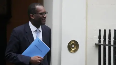 Reuters Chancellor Kwasi Kwarteng walks outside Downing Street in London