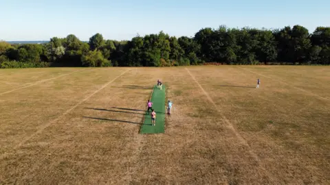 Reuters A general view of a dried out grass outfield during a T20 Last Man Stands cricket match between MK Stallions (batting) and MK Super Kings cricket clubs, in Milton Keynes, Britain, 10 August 2022.